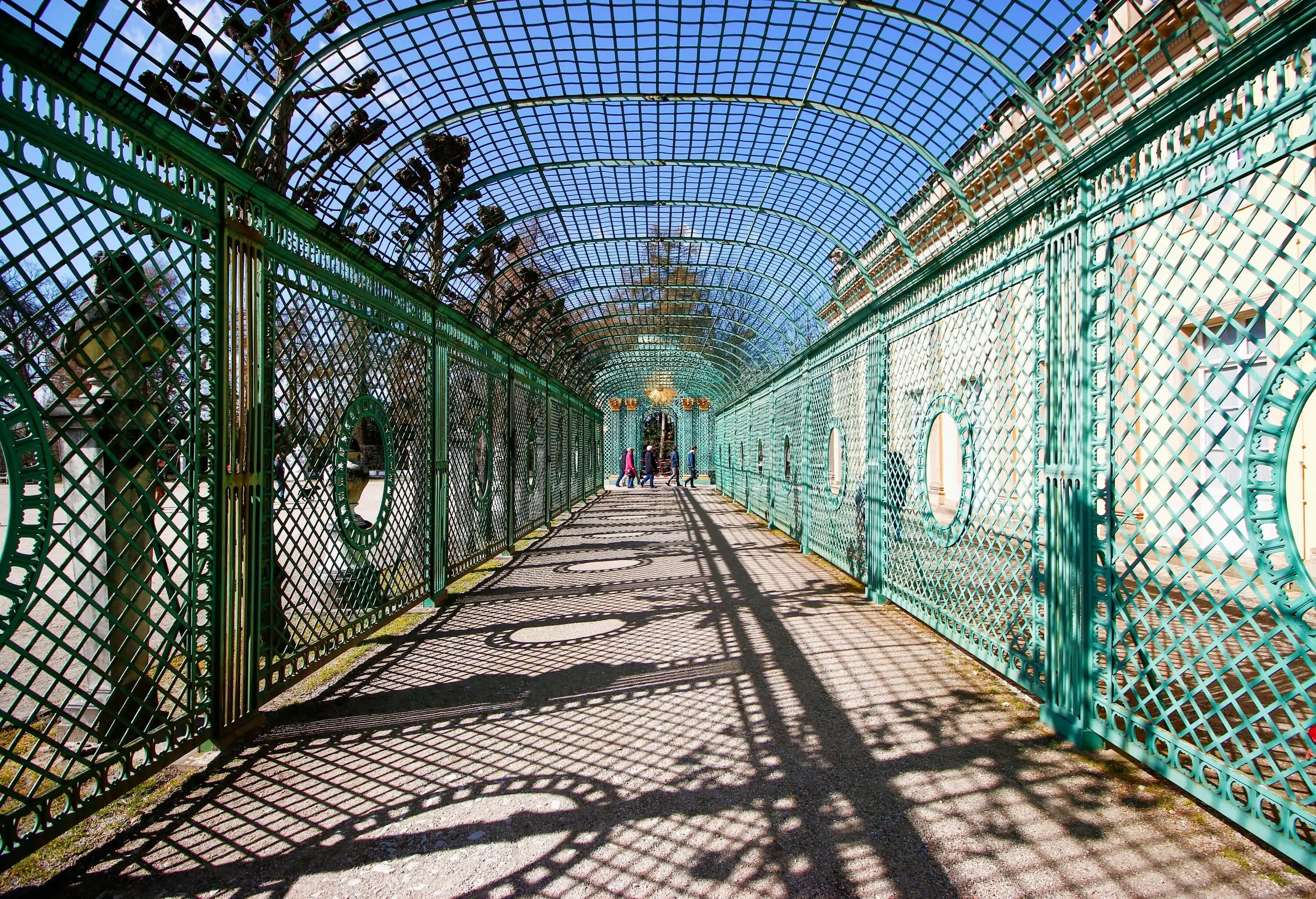 People cross in a caged walkway.