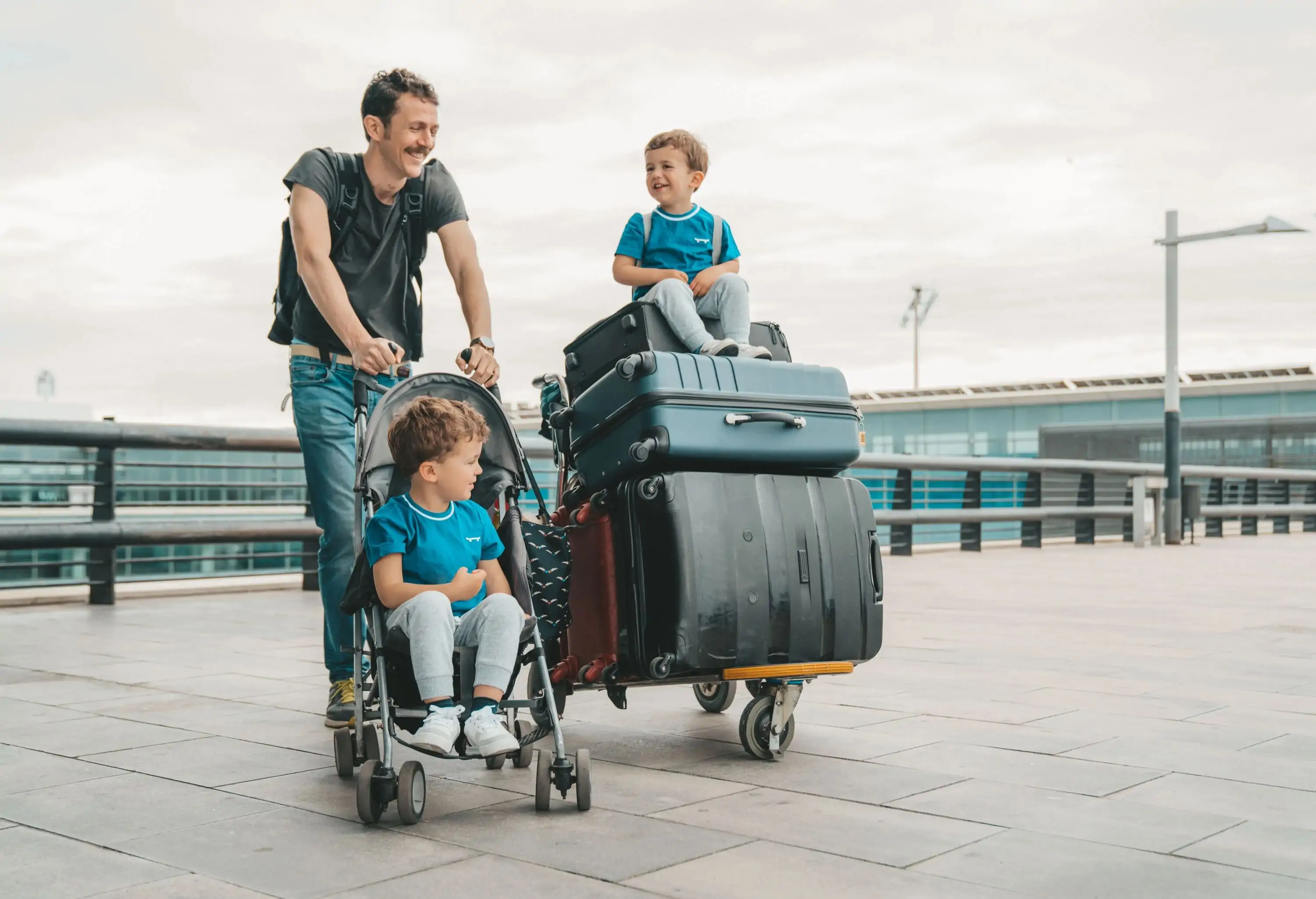 family with suitcases outside the airport