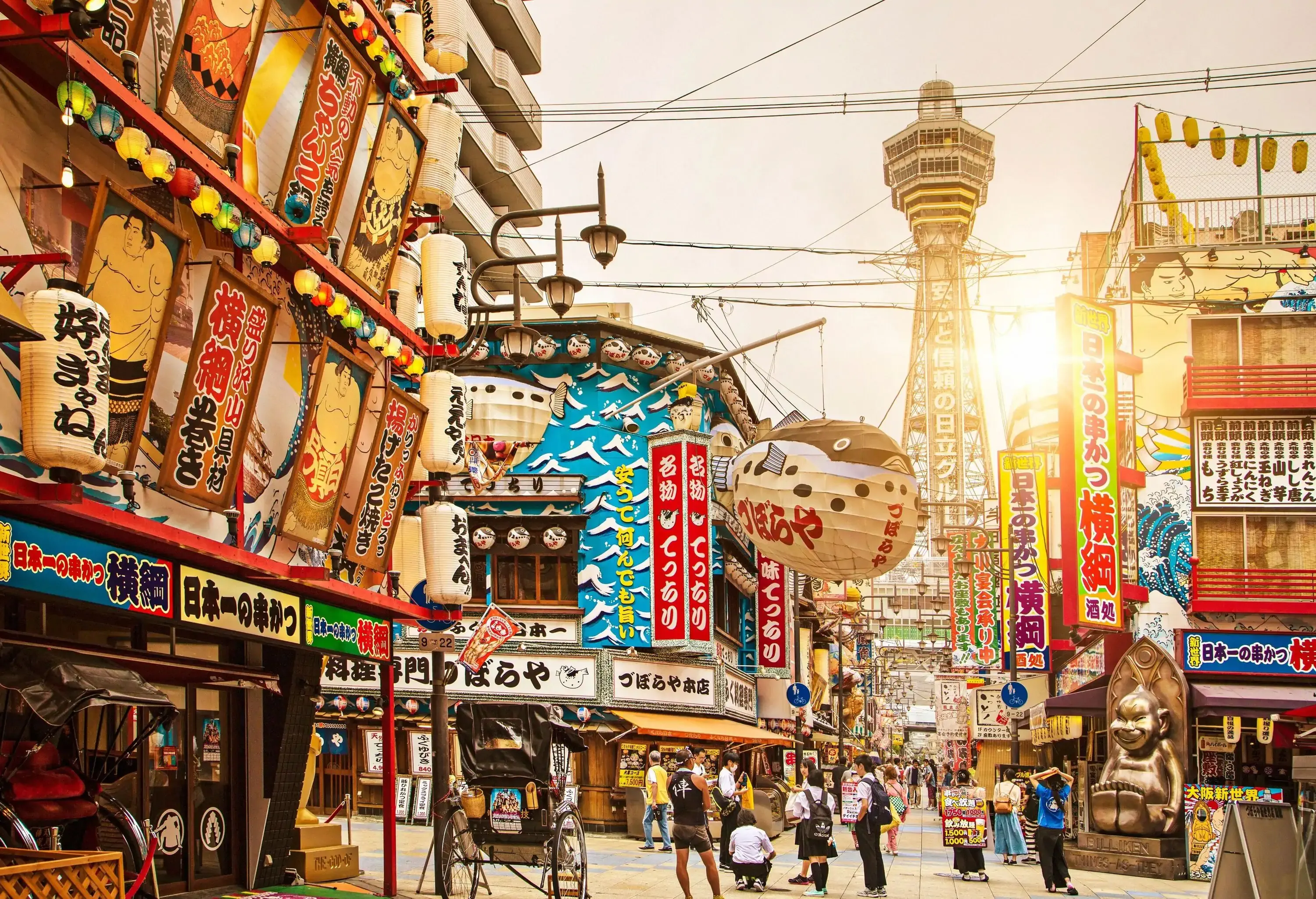  A vibrant and nostalgic neighbourhood boasting a unique blend of retro charm and contemporary energy, with its lively streets, and the iconic Tsutenkaku Tower in the centre.