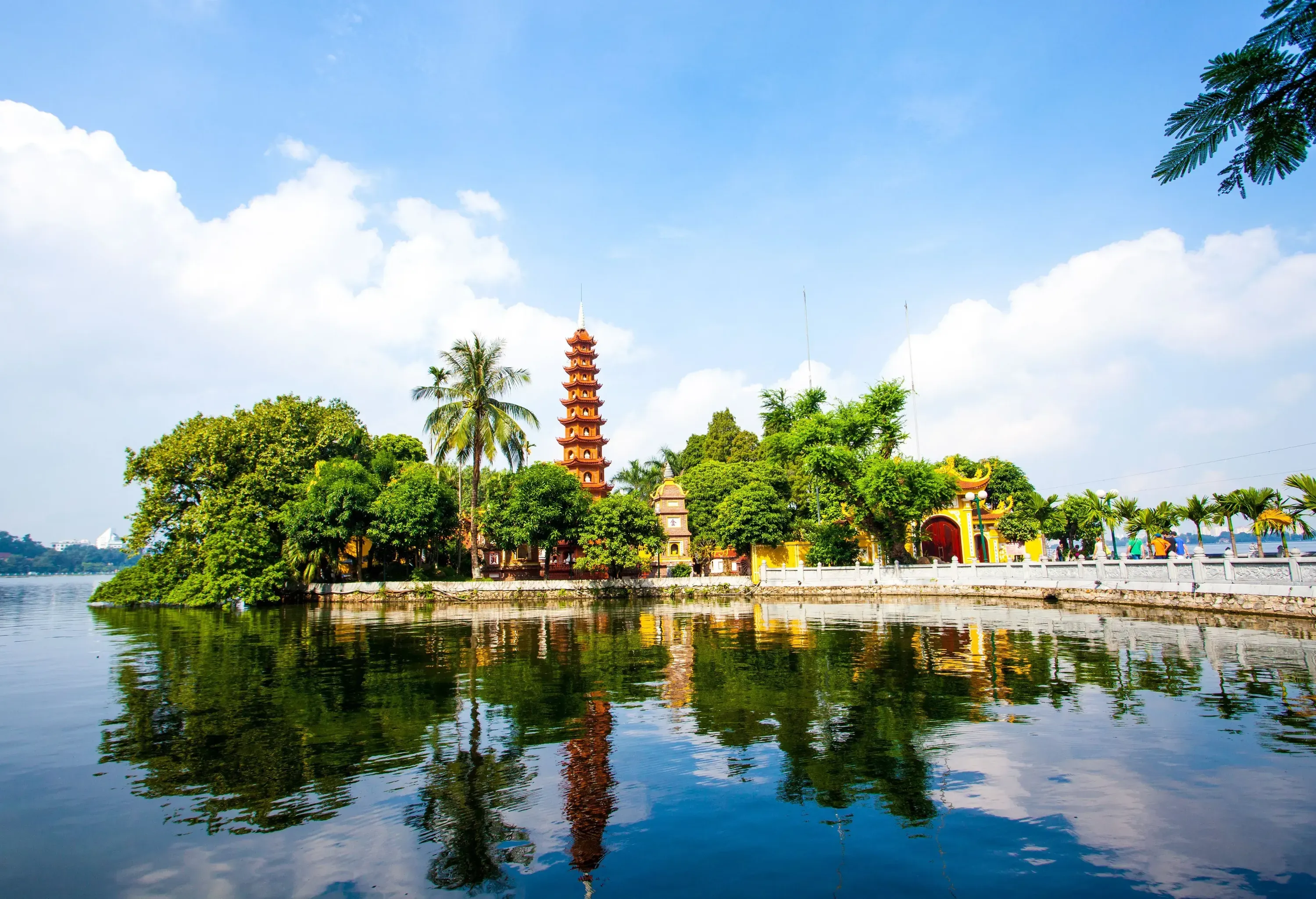 A lake with still waters mirrors the temple and the trees beside it.