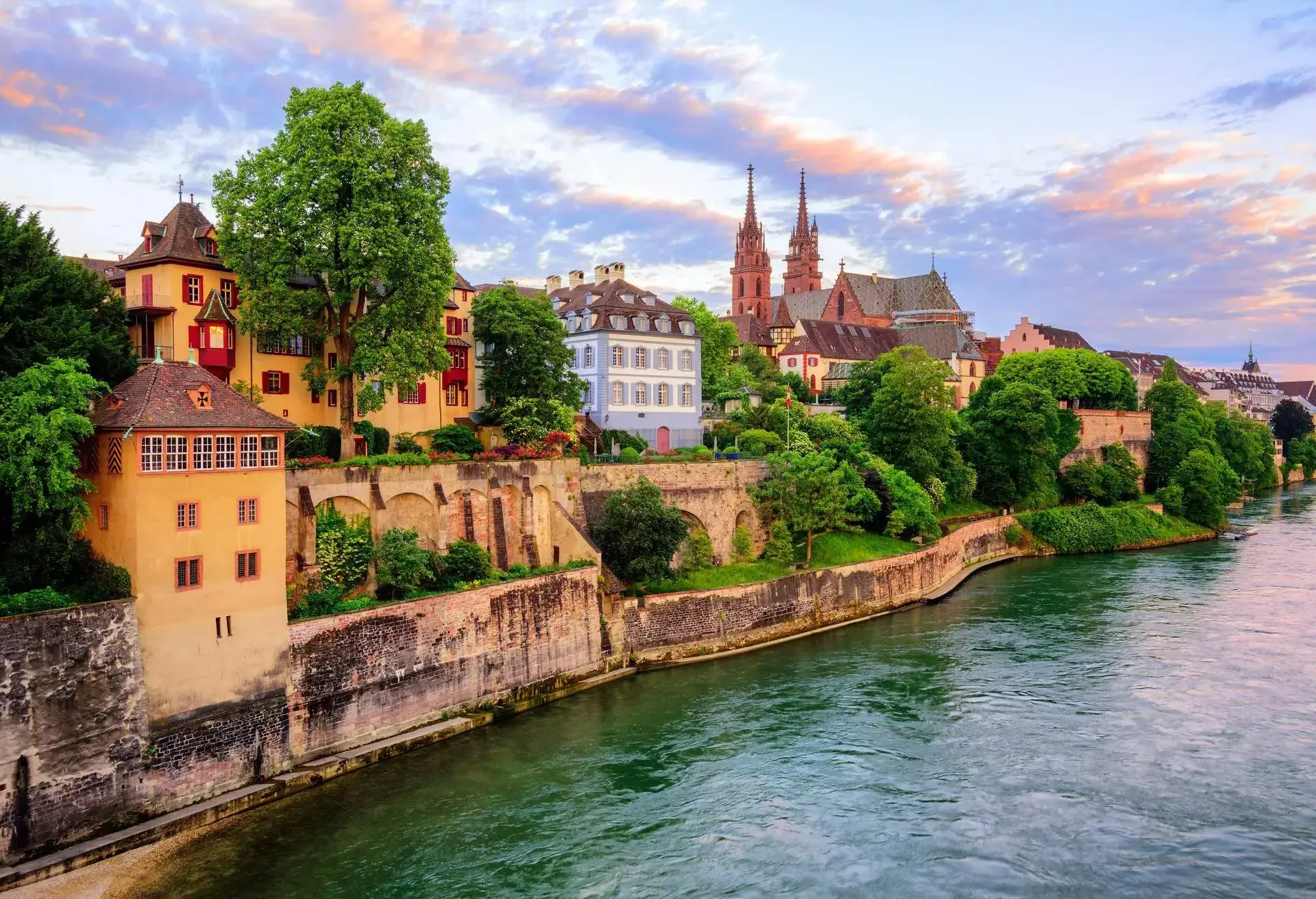 The Old Town of Basel with red stone Munster cathedral and the Rhine river, Switzerland, in dramatic sunset light