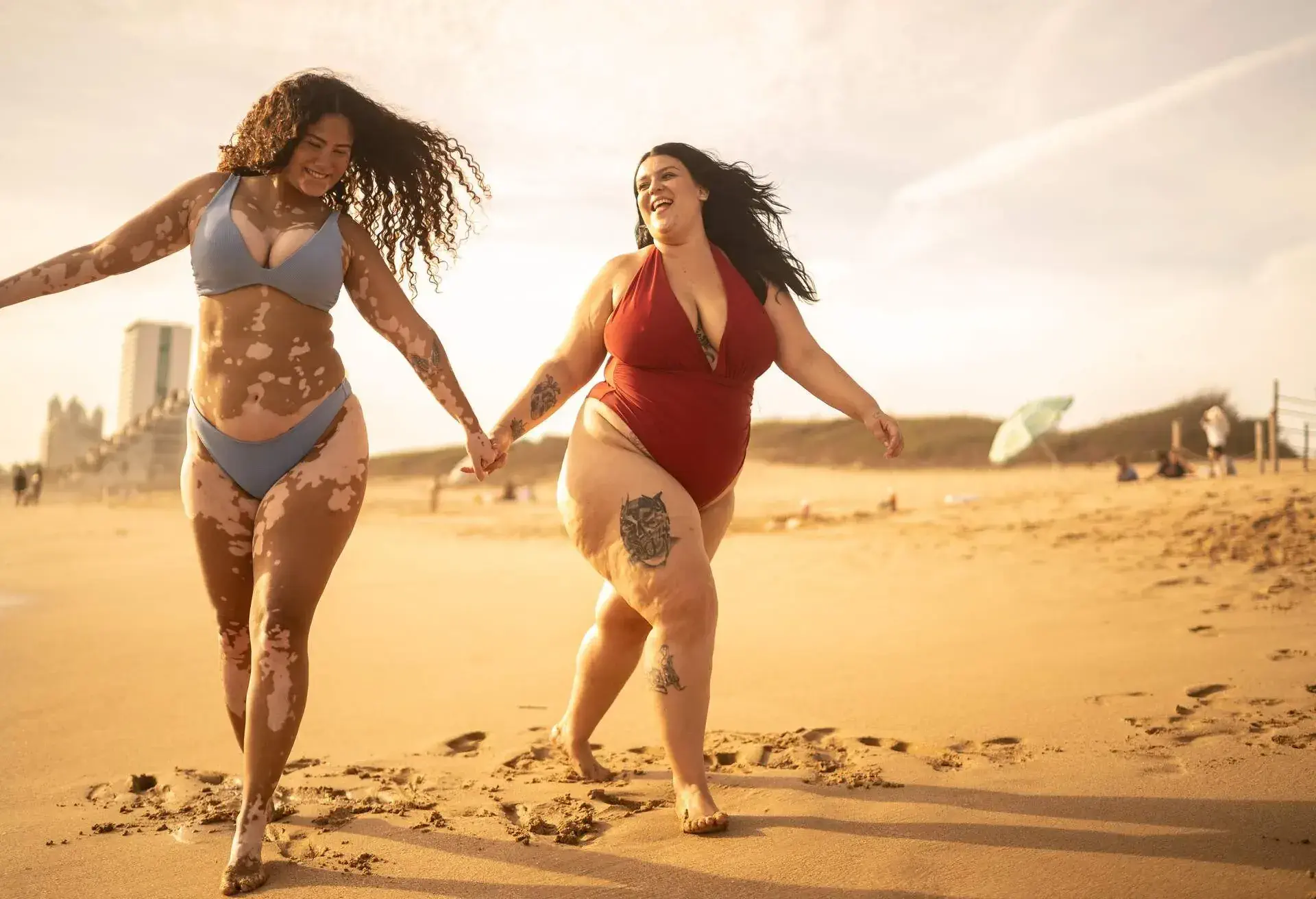 Friends holding hands walking in the beach