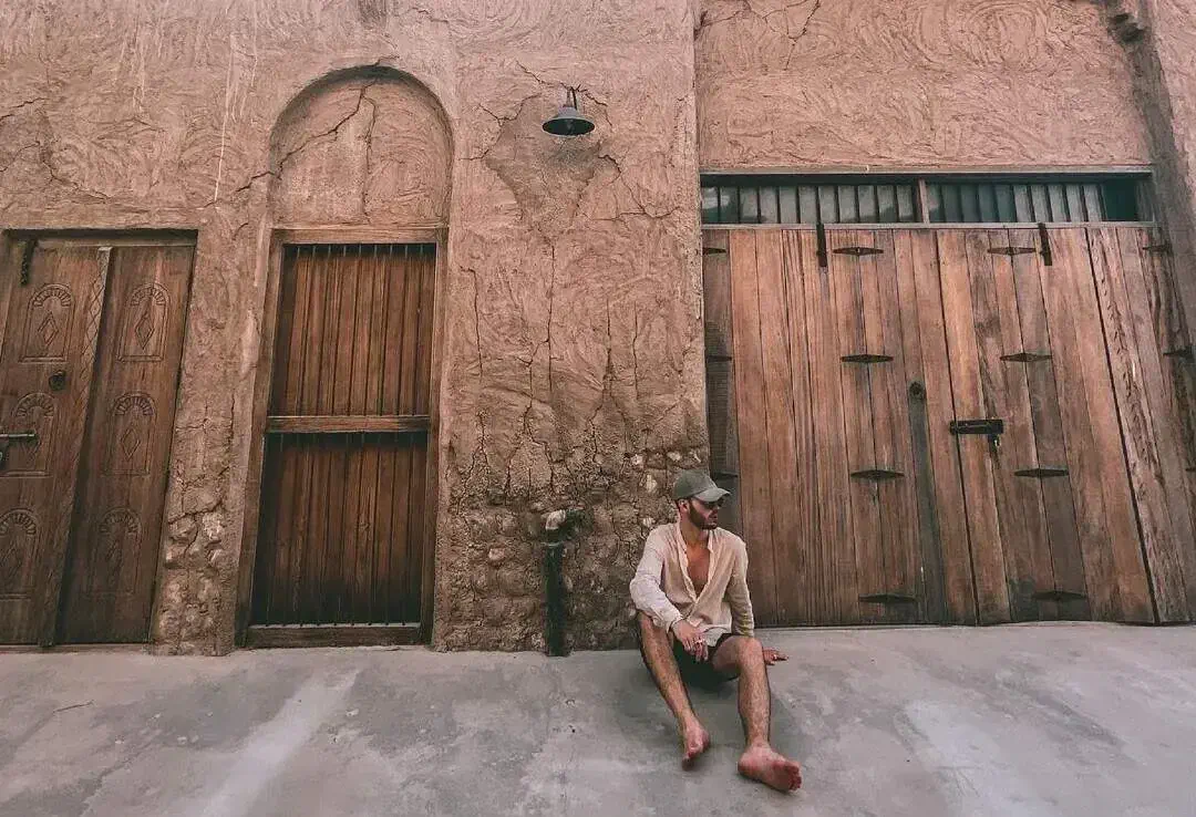 Male traveller sitting in front of doorways in ancient city