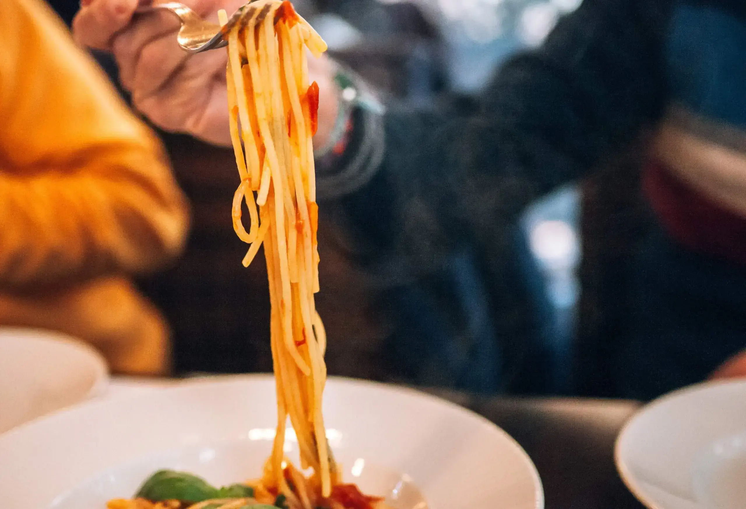 dest_italy_rome_restaurant_people_man_hand_holding_fork_with_spaghetti_gettyimages-1387105505