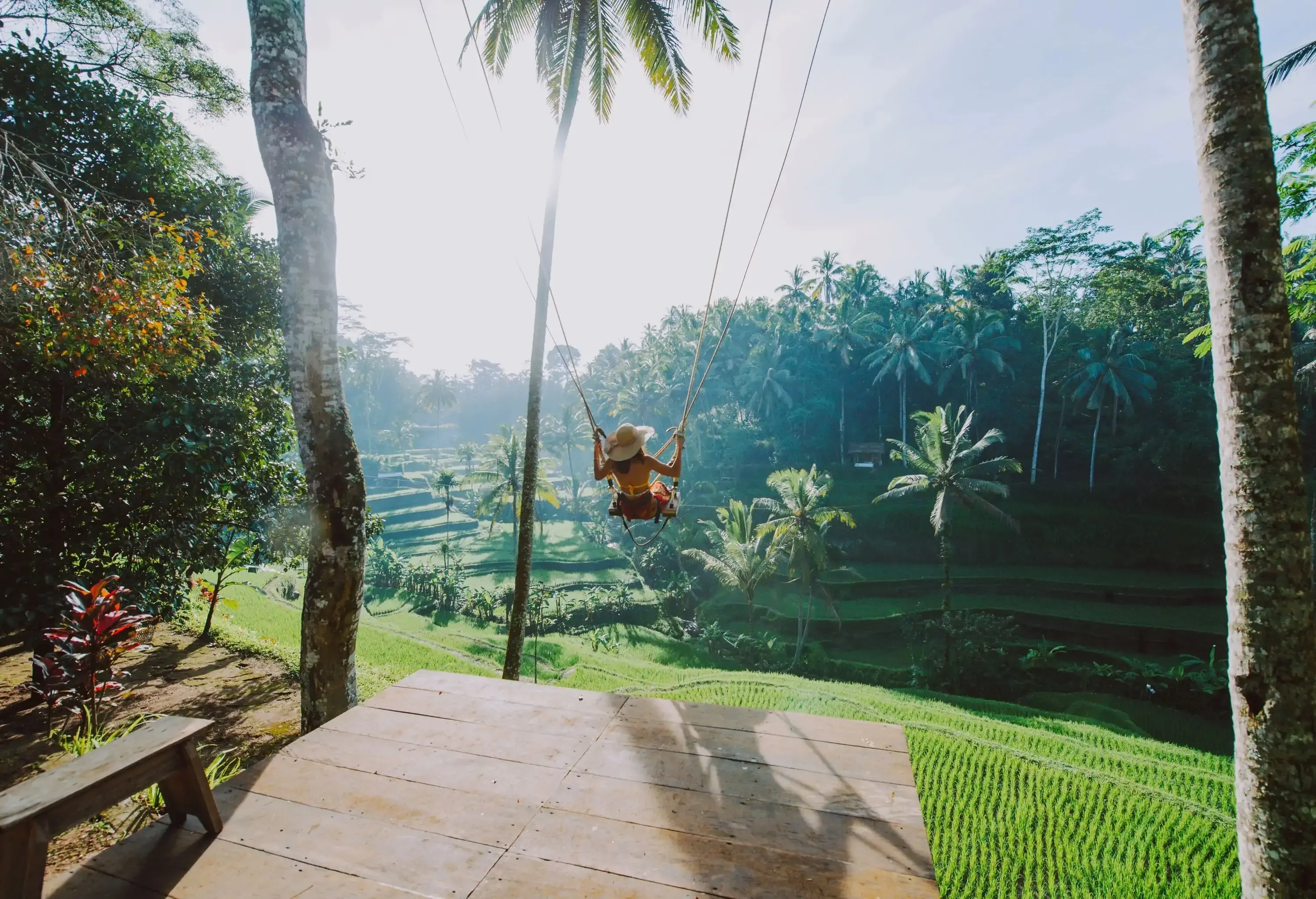 Woman on a swing over rice fields in ubud.