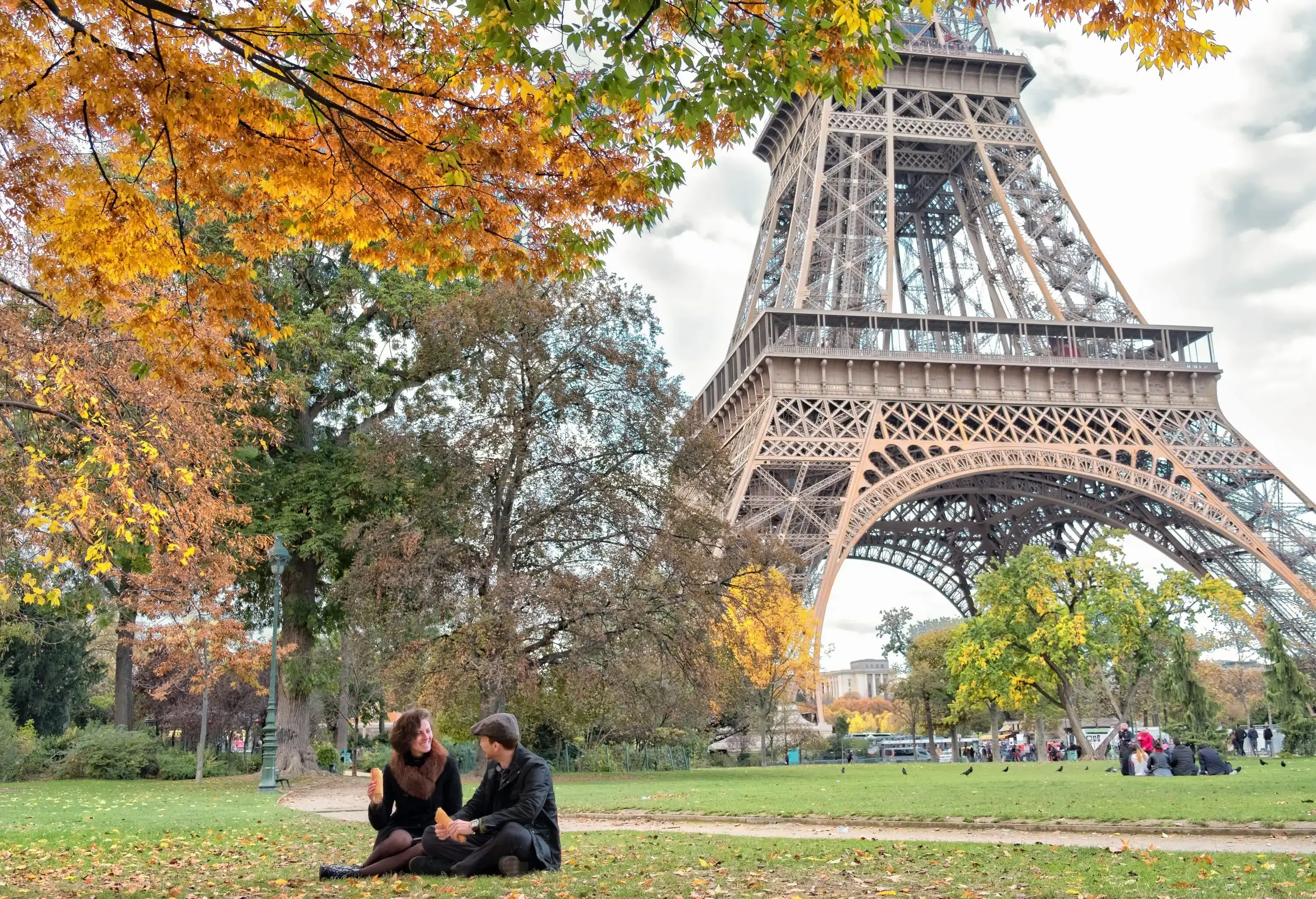 Couple relaxes at picnic by Eiffel Tower in Paris