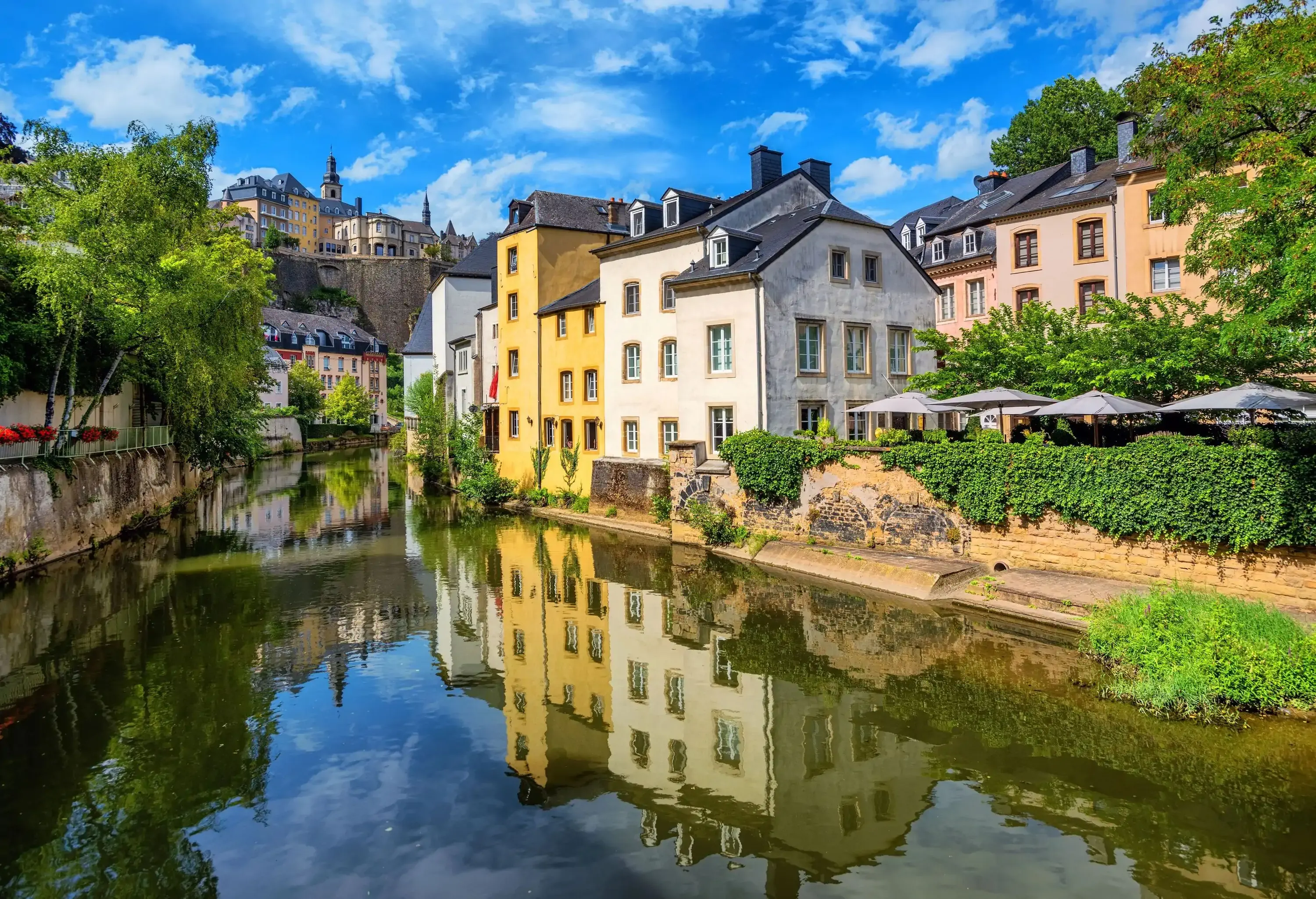 Luxembourg city, the capital of Grand Duchy of Luxembourg, view of the Old Town and Grund reflecting in Alzette river on a sunny summer day