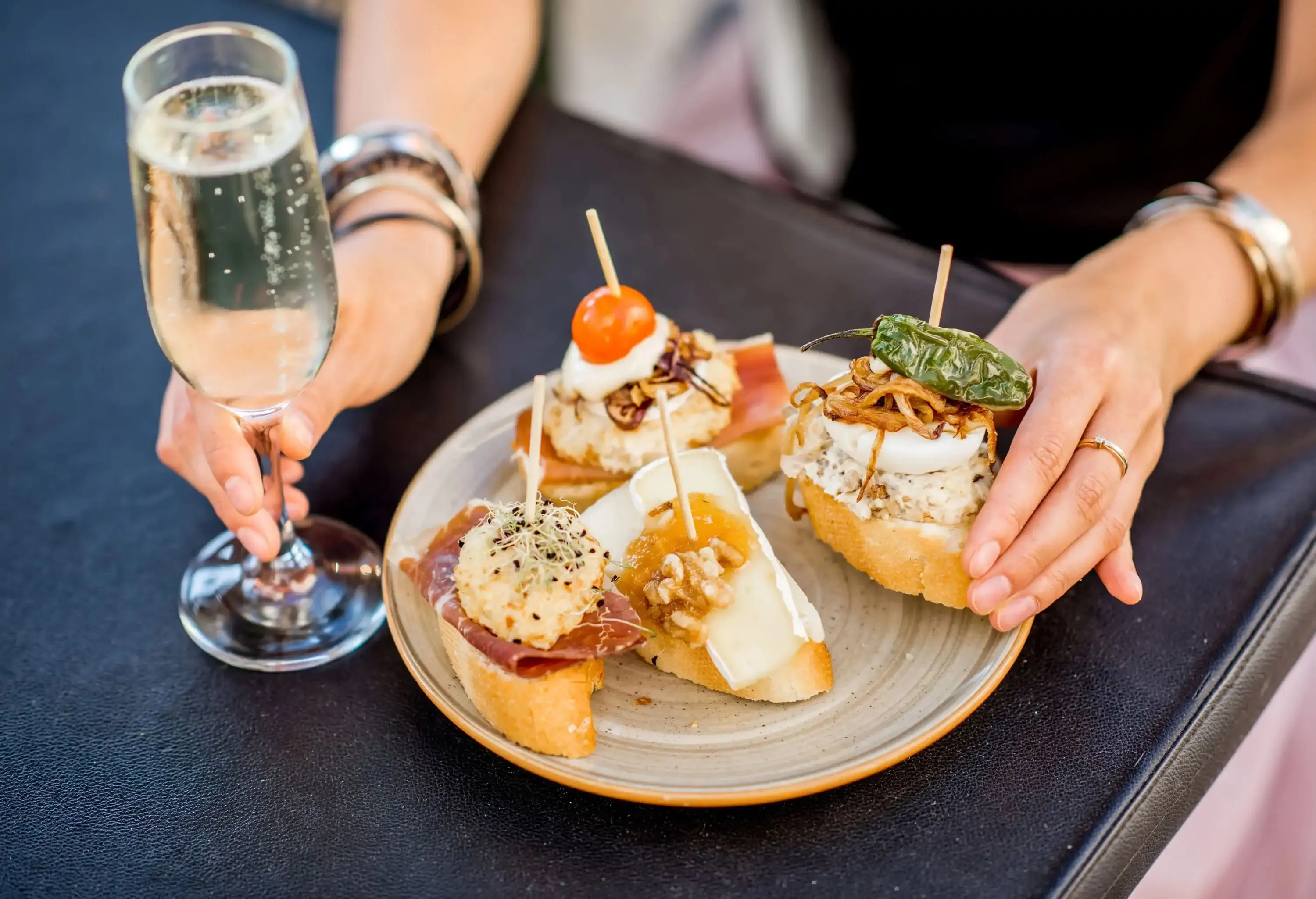 Beautiful and colorful set of pinchos, traditional spanish snack related to tapas, with glass of wine outdoors on the table