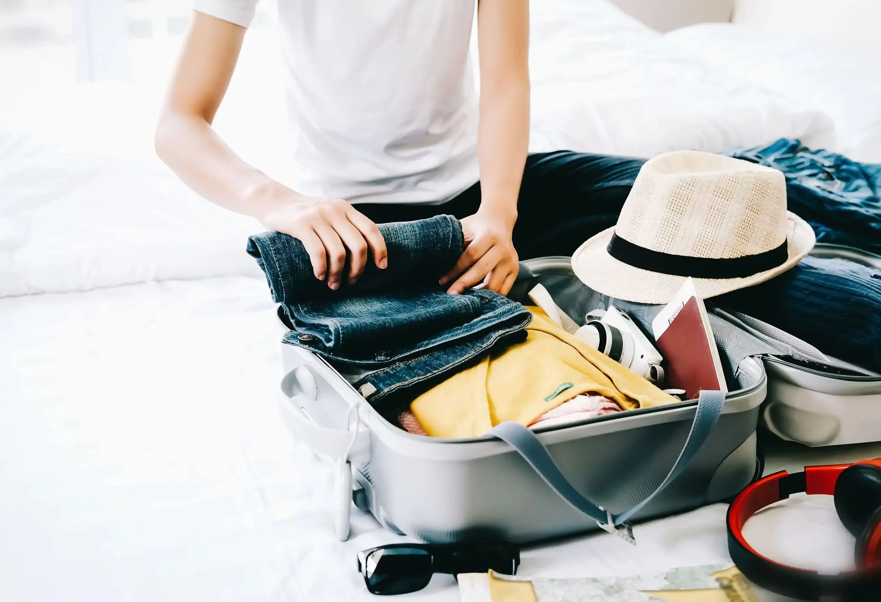 Woman packing travel bag for summer vacation.