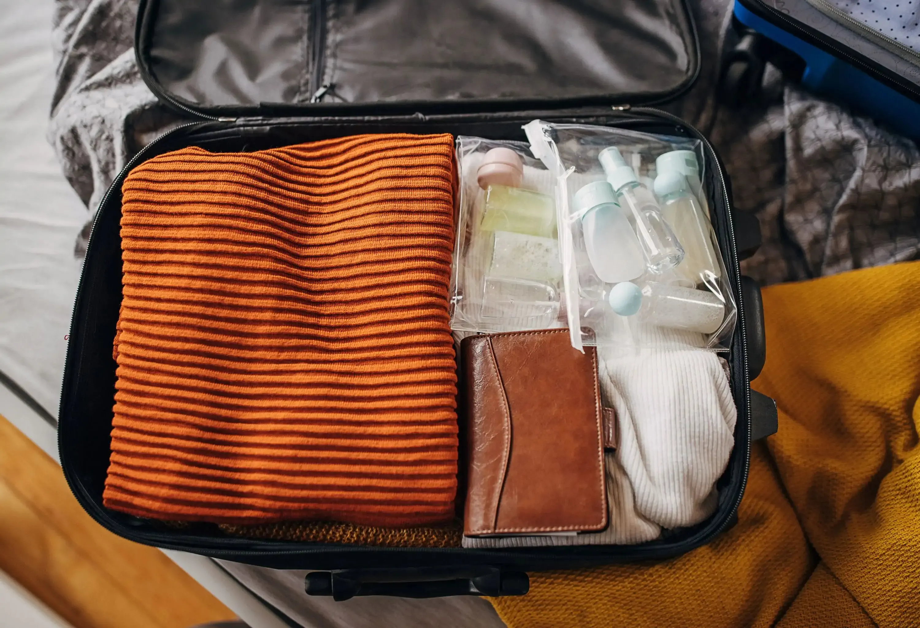 Clothes, cosmetics and essentials in hand luggage backpack at home