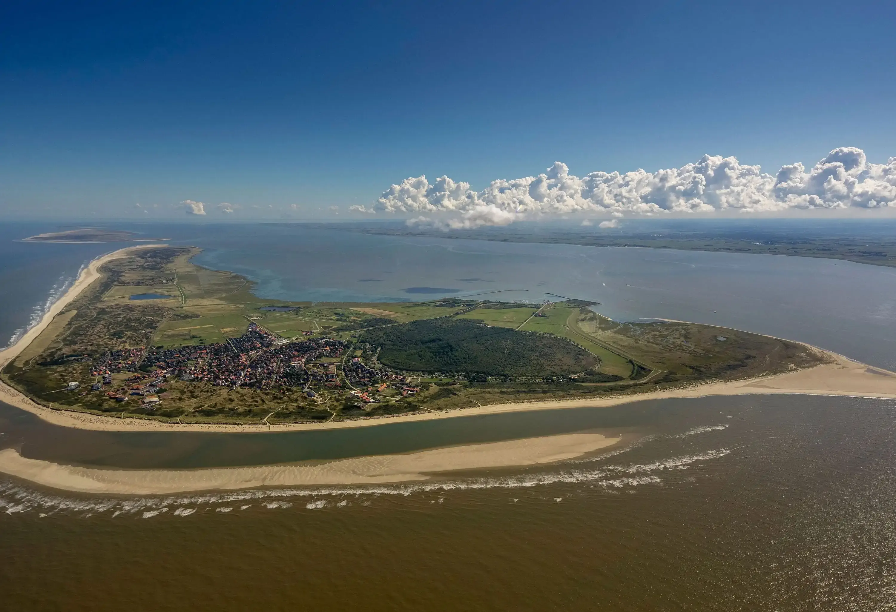 Sand banks forming around an inhabited island.