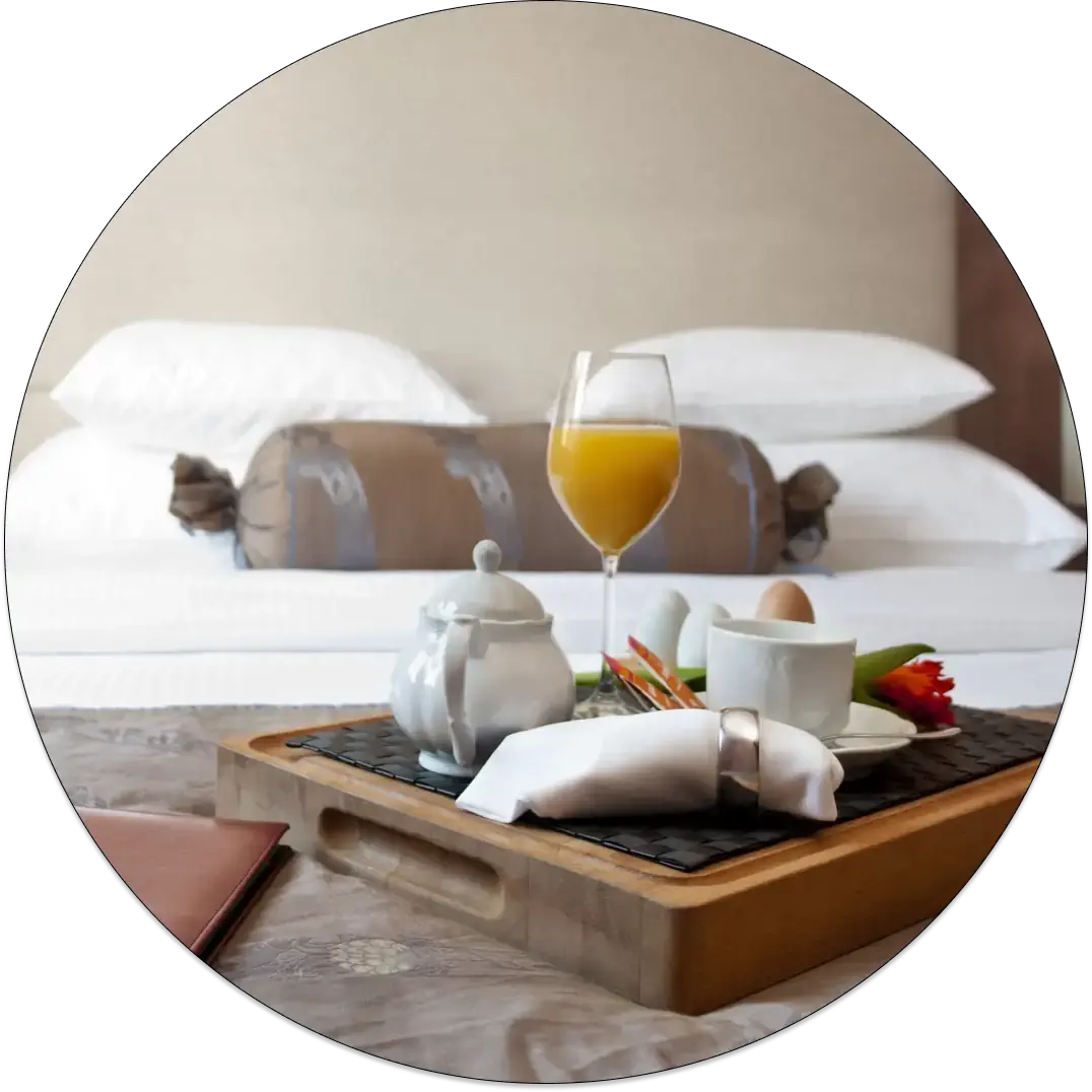 A hotel breakfast served in bed, elegantly arranged on a tray over crisp, fresh linens.