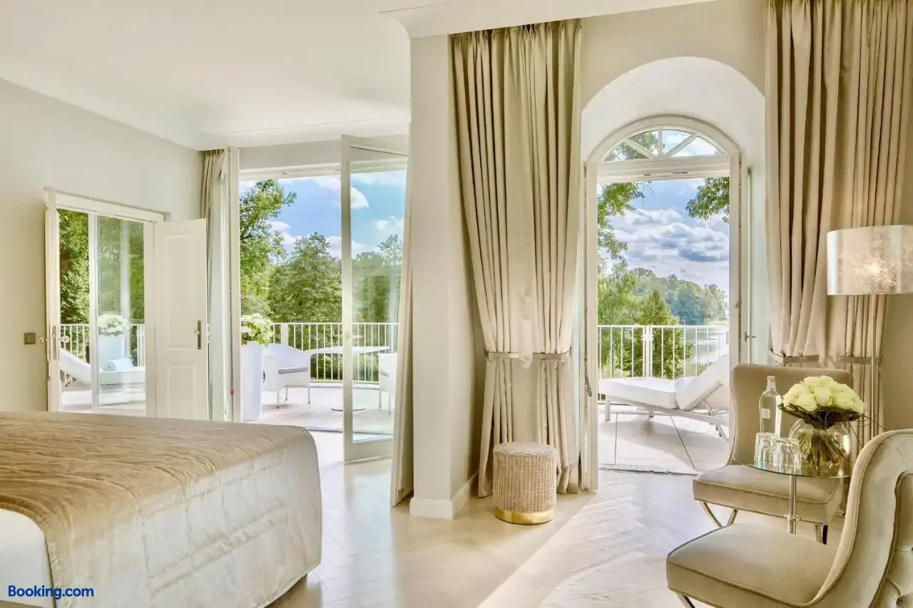 Luxury contemporary hotel room in neutral tones with view over greenery