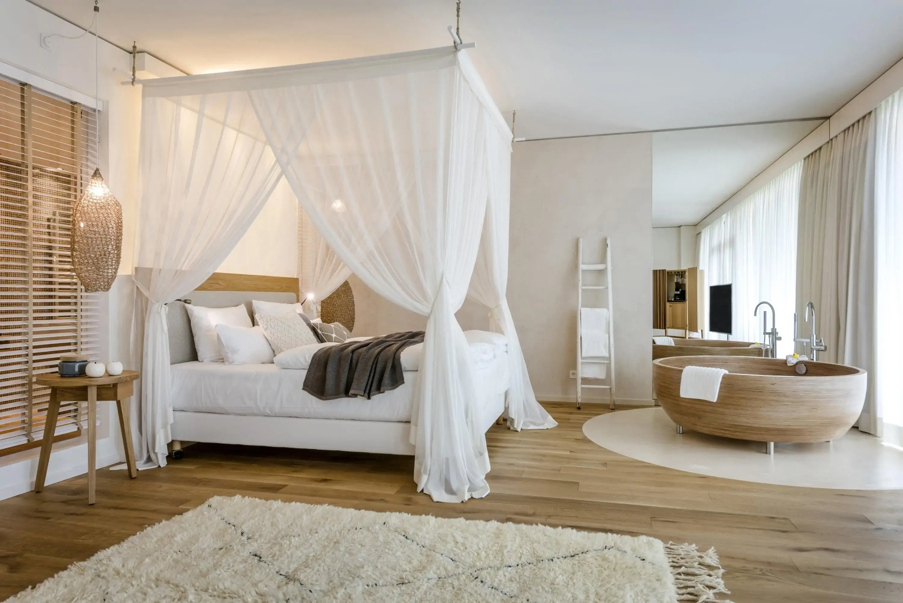 Luxury hotel room in modern Scandinavian style with four poster bed and free-standing bathtub