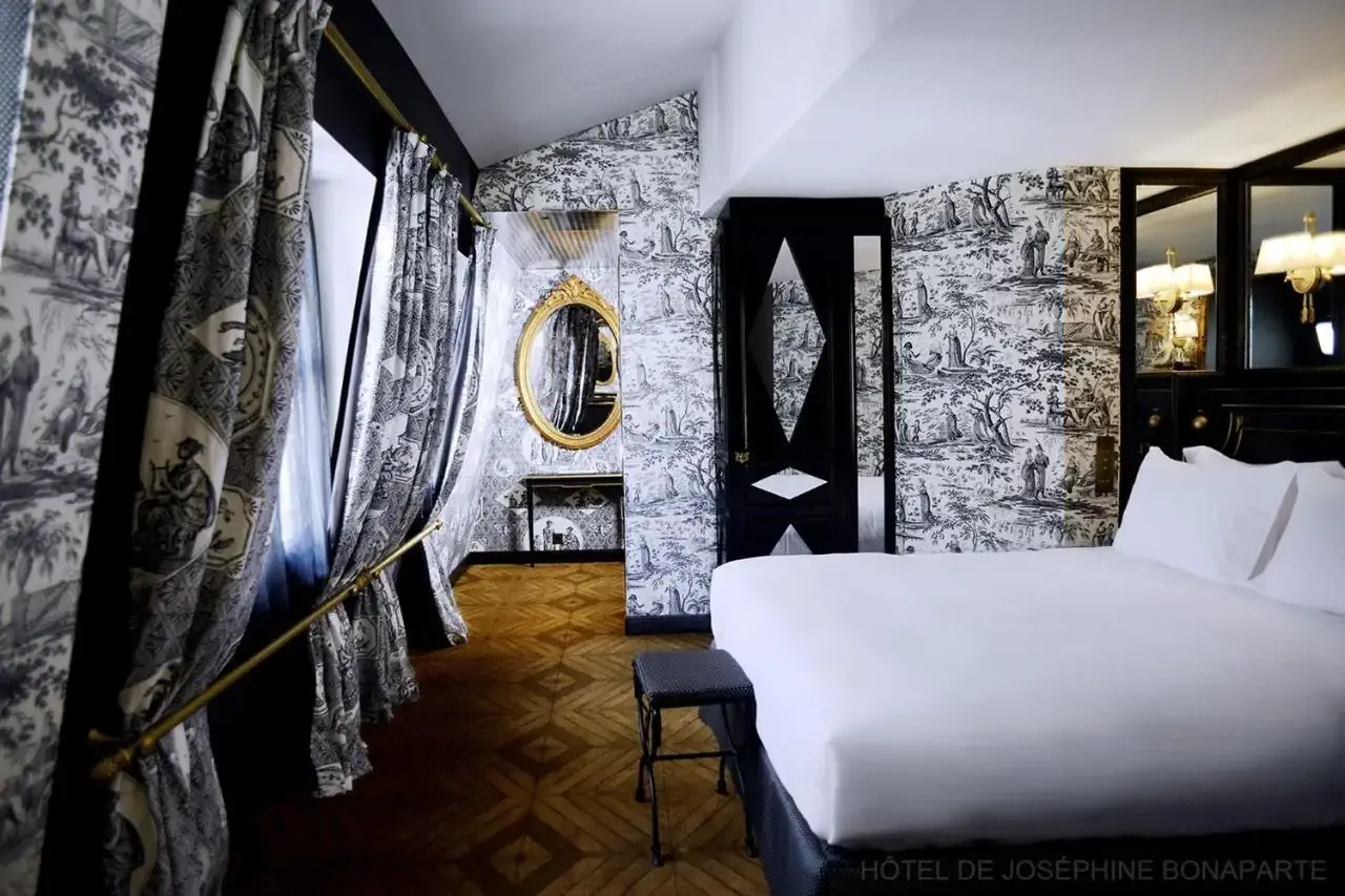 A luxury hotel room with black and white toile de jouy wallpaper